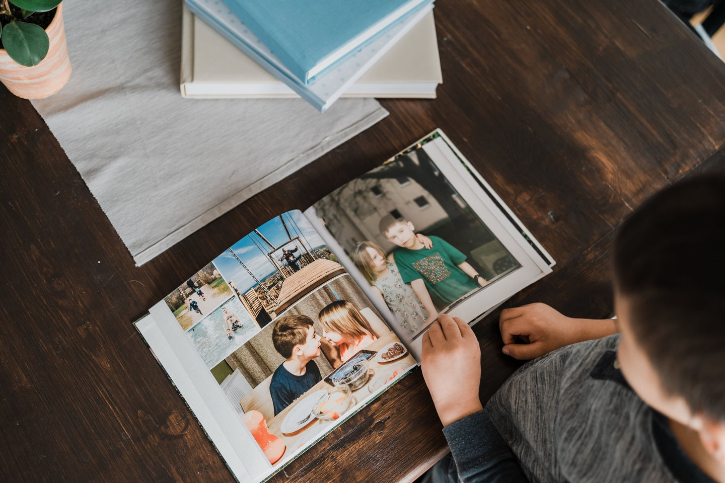 Kinder schauen Fotos in Familienfotobuch an