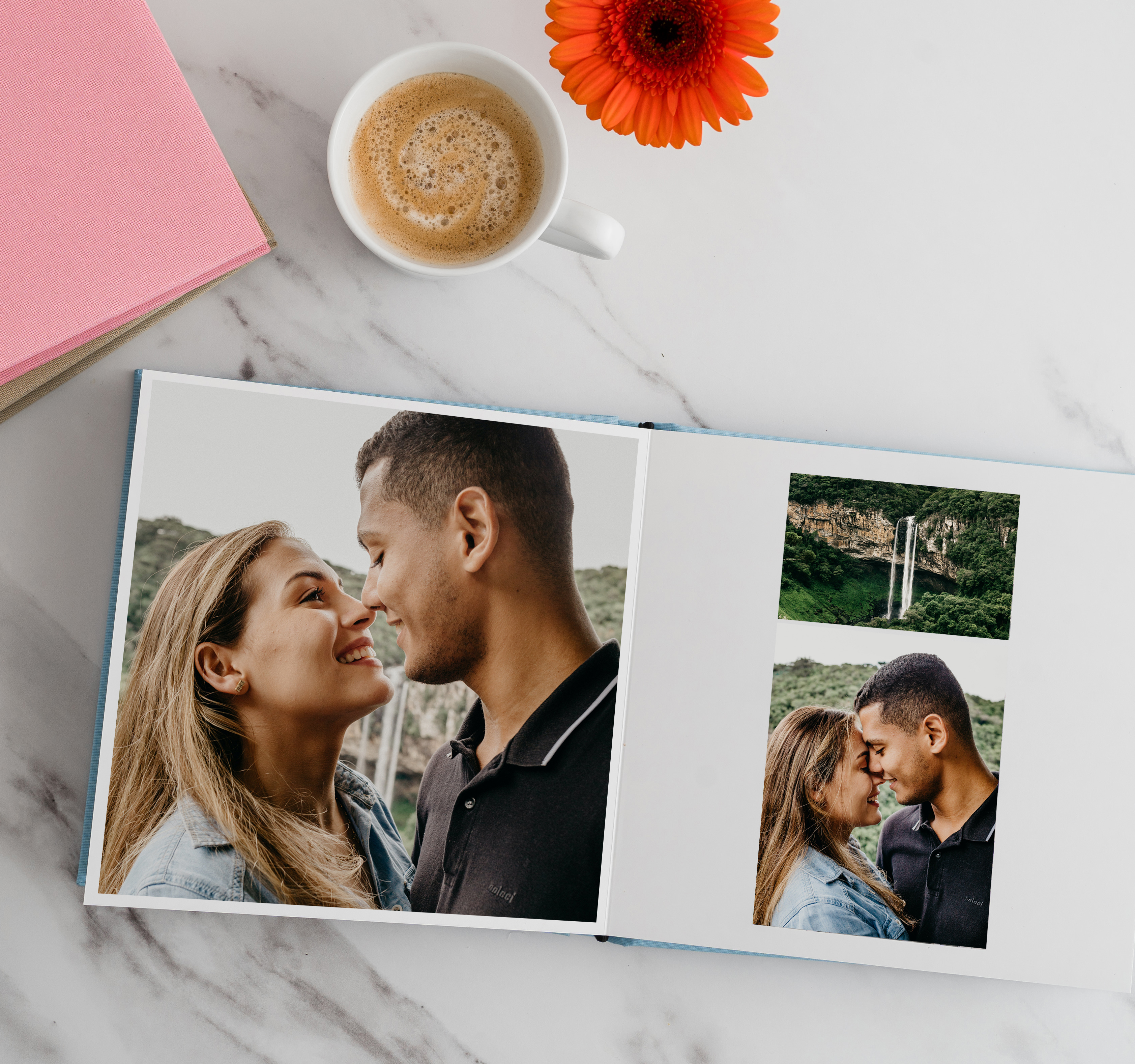 Fotobuch mit Verlobungsfotos von Paar neben Wasserfall