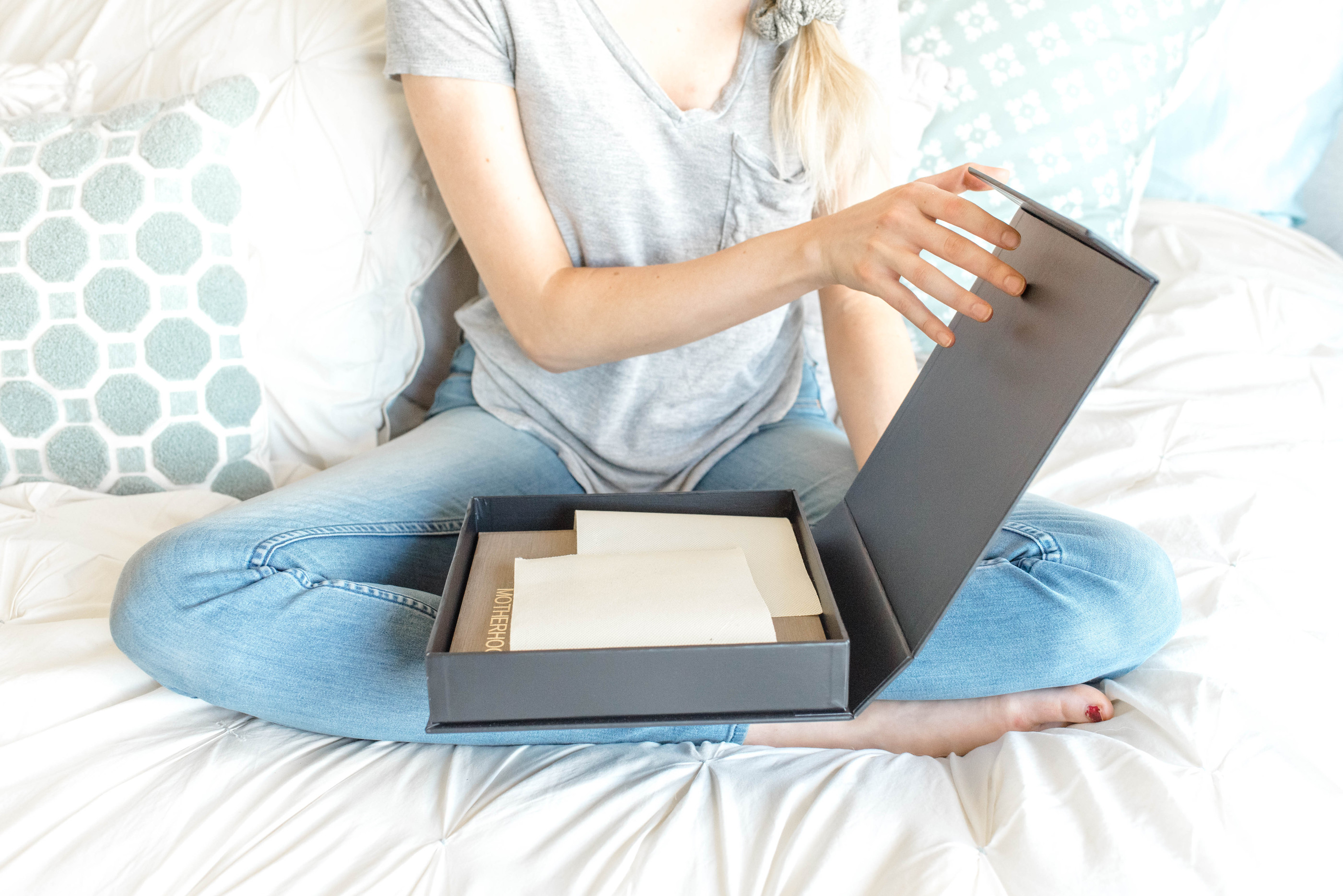 Women opening box with wedding album